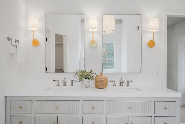 bathroom with double vanity and a spacious closet