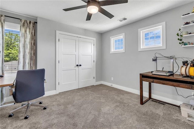 carpeted office with a ceiling fan and baseboards