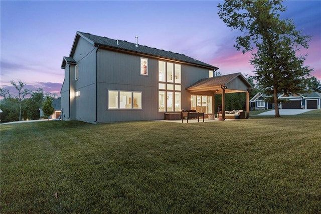 rear view of property featuring an outdoor hangout area, a yard, and a patio