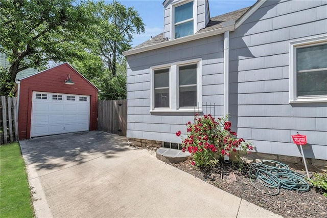 7126 Charlotte St, Kansas City, MO 64131 - view of side of home with a detached garage, an outdoor structure, driveway, and roof with shingles