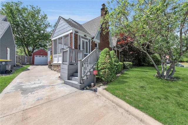 7126 Charlotte St, Kansas City, MO 64131 - view of front of home with an outdoor structure, a detached garage, roof with shingles, a front lawn, and driveway