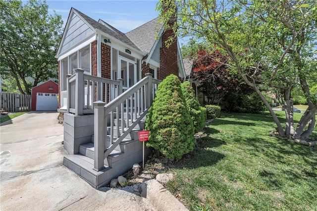 7126 Charlotte St, Kansas City, MO 64131 - view of home's exterior featuring an outdoor structure, brick siding, a detached garage, driveway, and roof with shingles