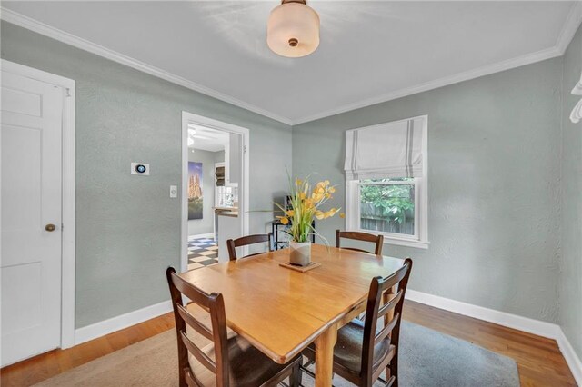 7126 Charlotte St, Kansas City, MO 64131 - dining area with crown molding, wood finished floors, and baseboards