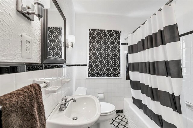 7126 Charlotte St, Kansas City, MO 64131 - full bathroom featuring tile walls, toilet, a sink, and shower / bath combo with shower curtain