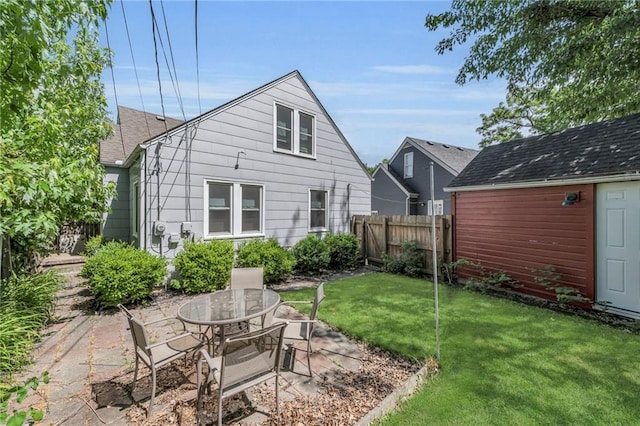 7126 Charlotte St, Kansas City, MO 64131 - back of house featuring a patio, an outbuilding, and a shingled roof