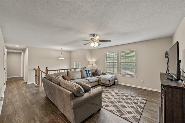 4700 E 136th Ct, Grandview, MO 64030 - living room with ceiling fan, dark wood-type flooring, a textured ceiling, and baseboards