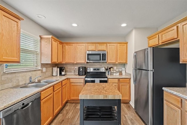 4700 E 136th Ct, Grandview, MO 64030 - kitchen featuring stainless steel appliances, a sink, light wood-style floors, backsplash, and light brown cabinets