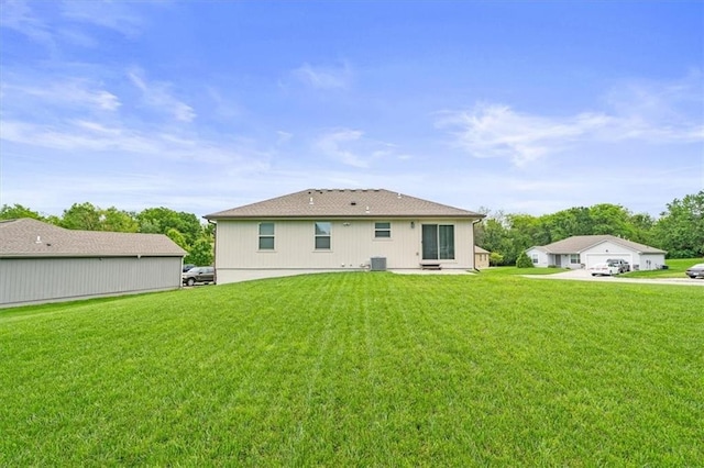 4700 E 136th Ct, Grandview, MO 64030 - back of house featuring a yard, a detached garage, and central air condition unit