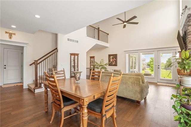 dining area with dark wood-type flooring, a ceiling fan, stairs, a high ceiling, and recessed lighting