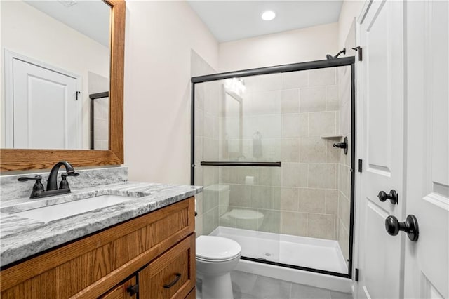 full bathroom featuring a shower stall, toilet, vanity, and tile patterned flooring