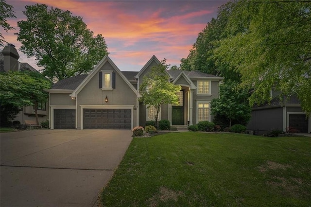 5817 W 147th Pl, Overland Park, KS 66223 - traditional-style house featuring driveway, a front yard, stucco siding, and an attached garage