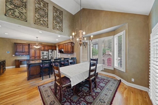 5817 W 147th Pl, Overland Park, KS 66223 - dining room featuring a chandelier, light wood-style floors, baseboards, and high vaulted ceiling
