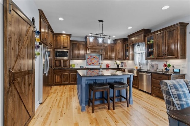 30307 Woodland Dr, Pleasant Hill, MO 64080 - kitchen featuring stainless steel appliances, a barn door, a sink, light wood-style flooring, and recessed lighting