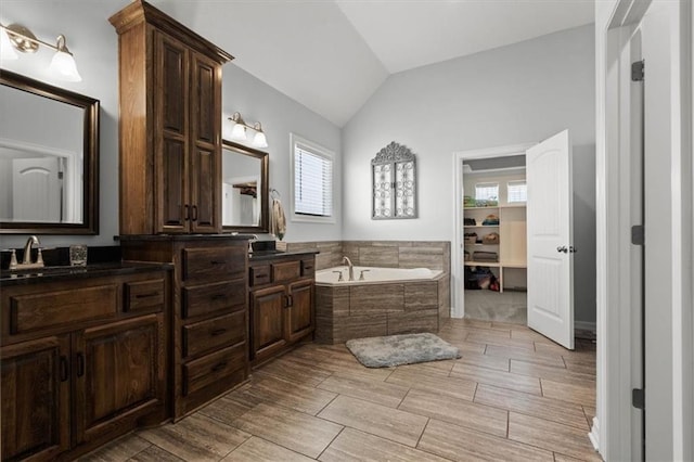 30307 Woodland Dr, Pleasant Hill, MO 64080 - full bathroom featuring lofted ceiling, a garden tub, double vanity, and wood tiled floors