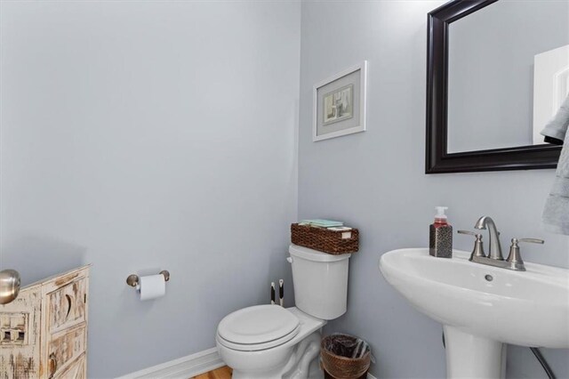 30307 Woodland Dr, Pleasant Hill, MO 64080 - bathroom featuring toilet, baseboards, and a sink