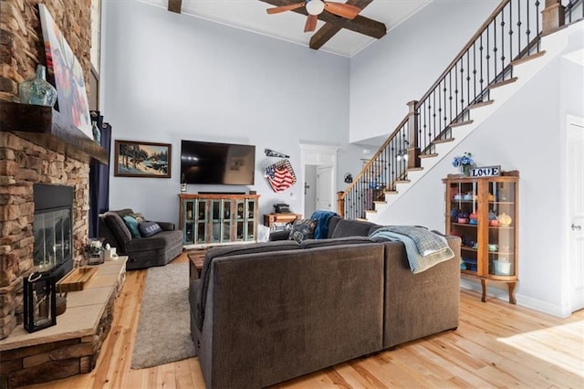 30307 Woodland Dr, Pleasant Hill, MO 64080 - living area with a towering ceiling, ceiling fan, a stone fireplace, wood finished floors, and stairs