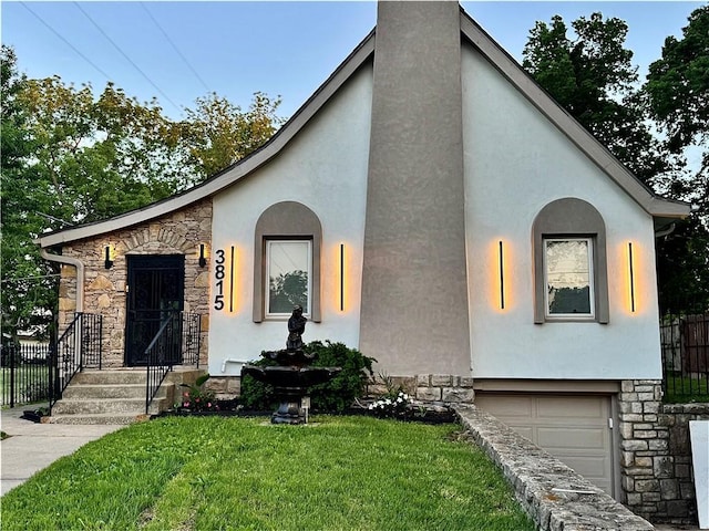 view of front of house featuring stone siding, stucco siding, and an attached garage