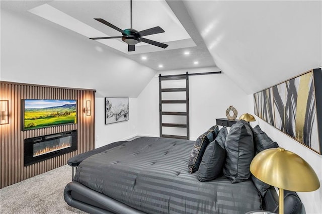 bedroom with lofted ceiling, carpet flooring, a glass covered fireplace, recessed lighting, and a barn door