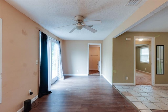 10101 E 18th St, Independence, MO 64052 - empty room with a ceiling fan, healthy amount of natural light, a textured ceiling, baseboards, and light wood-type flooring