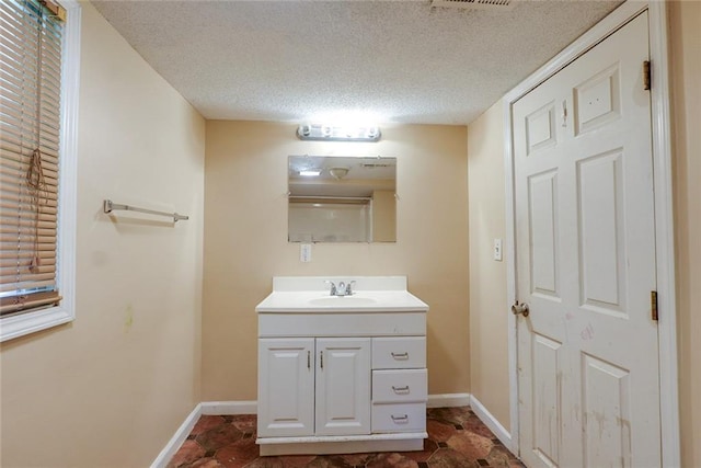 10101 E 18th St, Independence, MO 64052 - bathroom featuring vanity, baseboards, and a textured ceiling