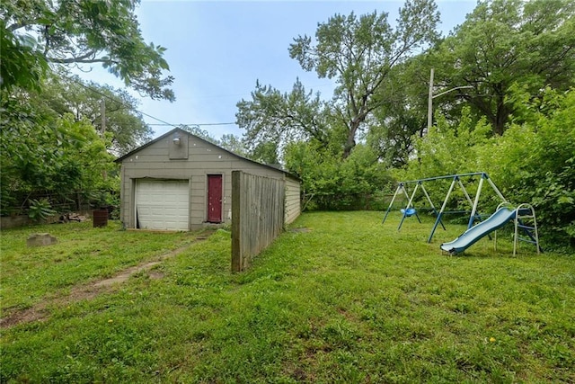 10101 E 18th St, Independence, MO 64052 - view of yard featuring a garage, a playground, driveway, and an outbuilding
