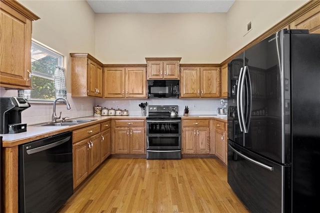 12434 England St, Overland Park, KS 66213 - kitchen featuring black appliances, light countertops, a sink, light wood-type flooring, and decorative backsplash