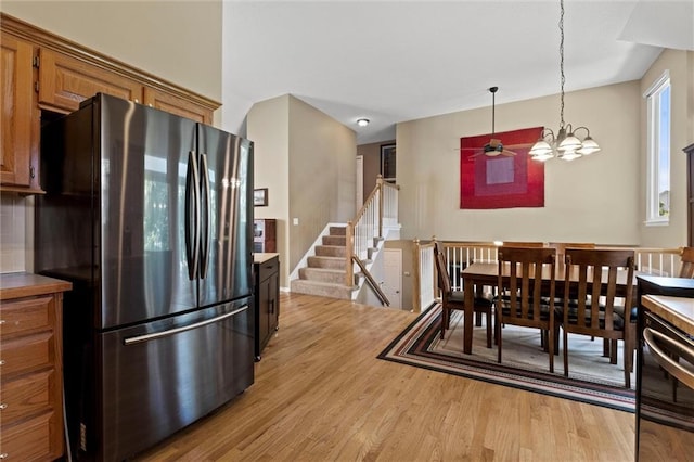 12434 England St, Overland Park, KS 66213 - dining area featuring light wood finished floors, a chandelier, and a ceiling fan