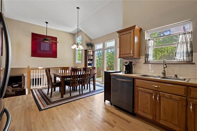 12434 England St, Overland Park, KS 66213 - kitchen featuring stainless steel dishwasher, a sink, brown cabinetry, light wood-style floors, and freestanding refrigerator