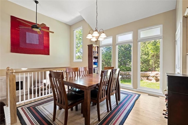 12434 England St, Overland Park, KS 66213 - dining space with light wood-style floors, a ceiling fan, a chandelier, and vaulted ceiling