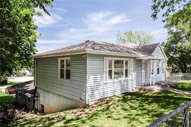 view of side of property with roof with shingles