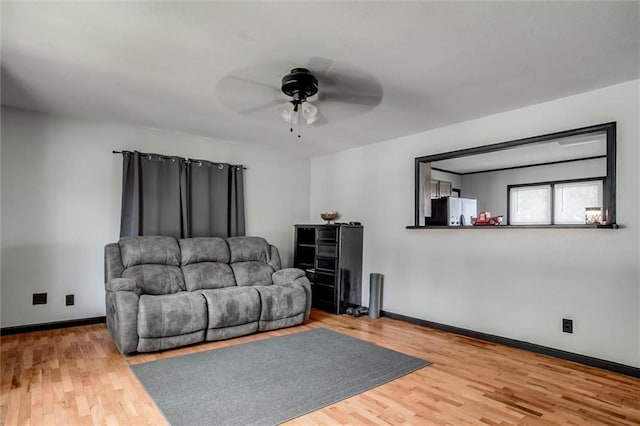 living area with ceiling fan, wood finished floors, and baseboards