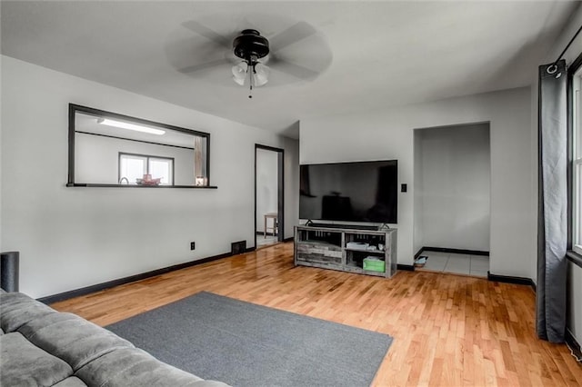 living room with wood finished floors, ceiling fan, and baseboards