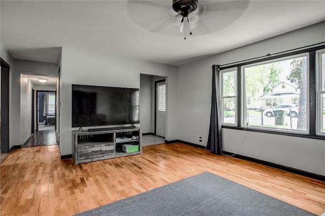 living area featuring ceiling fan, wood finished floors, and baseboards