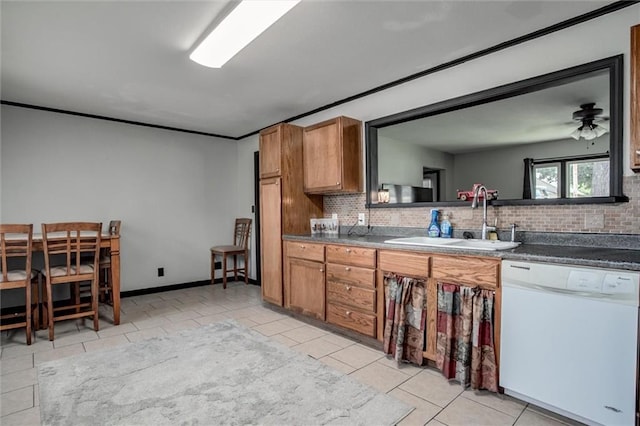 kitchen featuring white dishwasher, a sink, backsplash, and light tile patterned floors