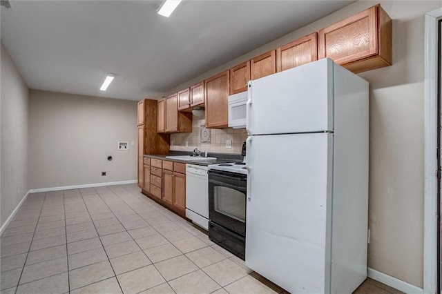 kitchen with white appliances, a sink, tasteful backsplash, baseboards, and light tile patterned flooring