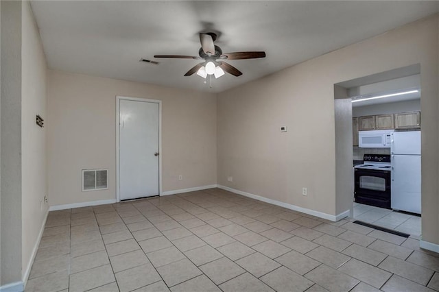 spare room with a ceiling fan, light tile patterned floors, and baseboards