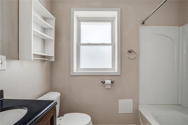 bathroom featuring toilet, vanity, and tub / shower combination