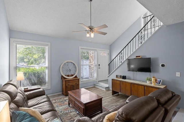 613 NE 90th Ter, Kansas City, MO 64155 - living area featuring a textured ceiling, stairs, wood finished floors, and a ceiling fan