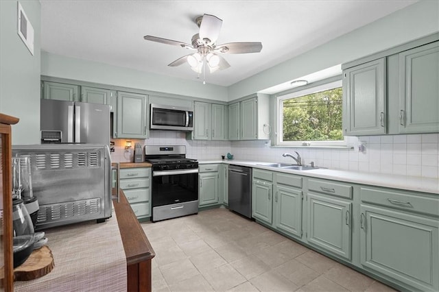 613 NE 90th Ter, Kansas City, MO 64155 - kitchen featuring stainless steel appliances, green cabinets, tasteful backsplash, and ceiling fan