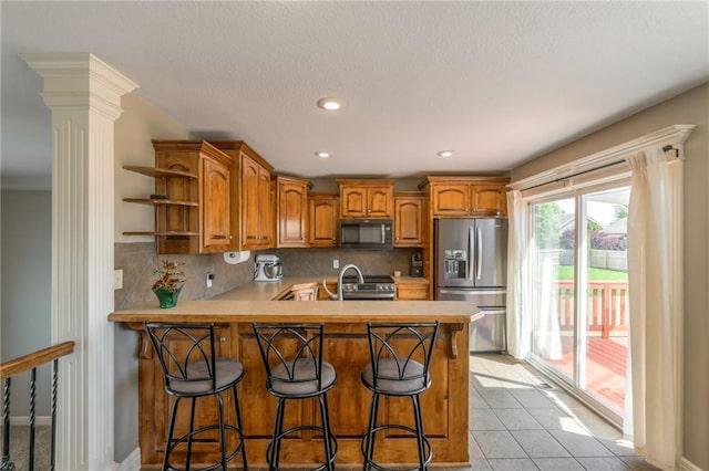 803 Crestridge Dr, Kearney, MO 64060 - kitchen with appliances with stainless steel finishes, brown cabinetry, open shelves, a peninsula, and decorative backsplash