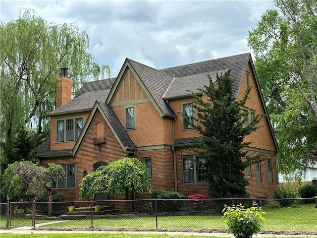 2702 Faraon St, Saint Joseph, MO 64501 - tudor home featuring a chimney, brick siding, and roof with shingles