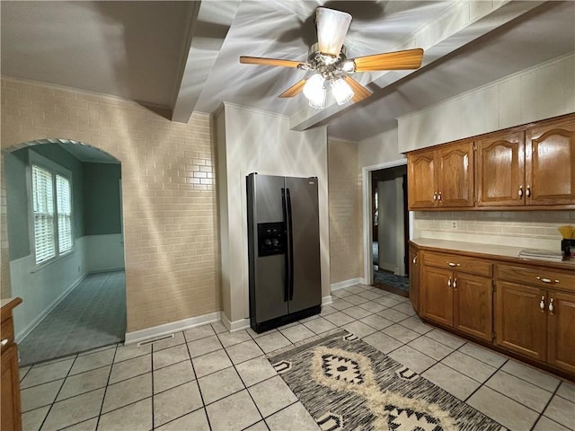 2702 Faraon St, Saint Joseph, MO 64501 - kitchen with stainless steel fridge with ice dispenser, arched walkways, ceiling fan, brick wall, and brown cabinets