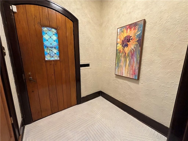 2702 Faraon St, Saint Joseph, MO 64501 - entrance foyer with arched walkways, carpet floors, baseboards, and a textured wall