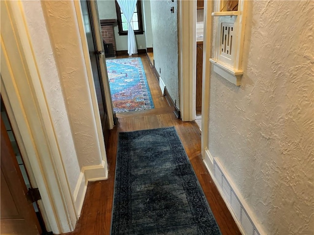 2702 Faraon St, Saint Joseph, MO 64501 - hallway featuring a textured wall, hardwood / wood-style floors, and baseboards
