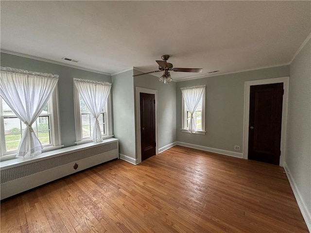 2702 Faraon St, Saint Joseph, MO 64501 - unfurnished bedroom featuring wood finished floors, ornamental molding, radiator heating unit, baseboards, and a ceiling fan