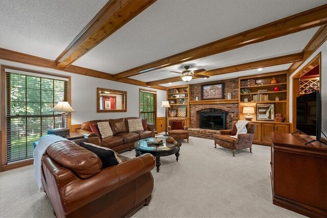 12224 Connell Dr, Overland Park, KS 66213 - living area featuring carpet flooring, a textured ceiling, beam ceiling, ceiling fan, and a brick fireplace