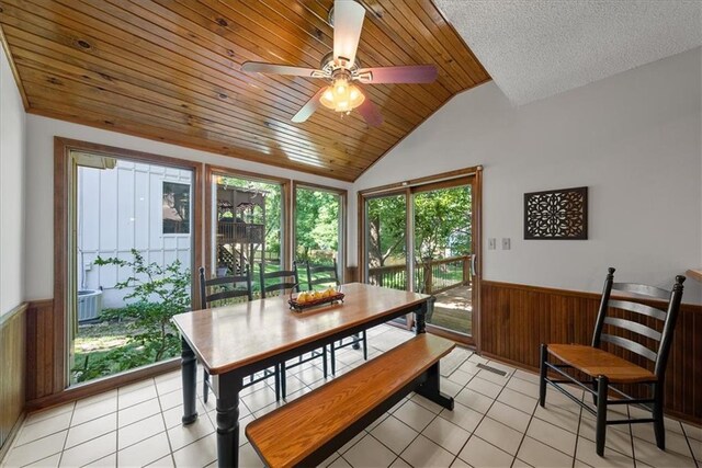 12224 Connell Dr, Overland Park, KS 66213 - dining area featuring a wainscoted wall, lofted ceiling, wooden walls, a ceiling fan, and light tile patterned floors