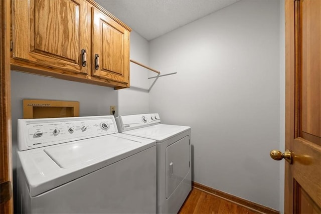 12224 Connell Dr, Overland Park, KS 66213 - laundry room with washer and clothes dryer, cabinet space, dark wood-style floors, and a textured ceiling