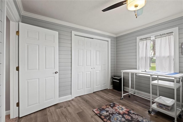 13223 Gammon Rd, Lees Summit, MO 64086 - bedroom with crown molding, wood finished floors, a closet, wooden walls, and a ceiling fan