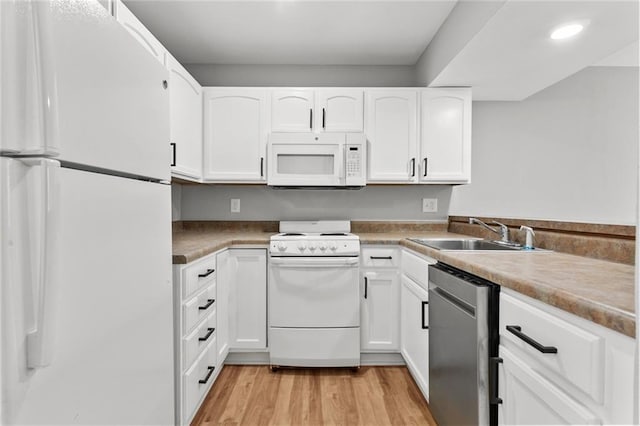 1506 W 25th Ct Unit E5, Lawrence, KS 66046 - kitchen with white appliances, a sink, white cabinets, light wood-style floors, and recessed lighting